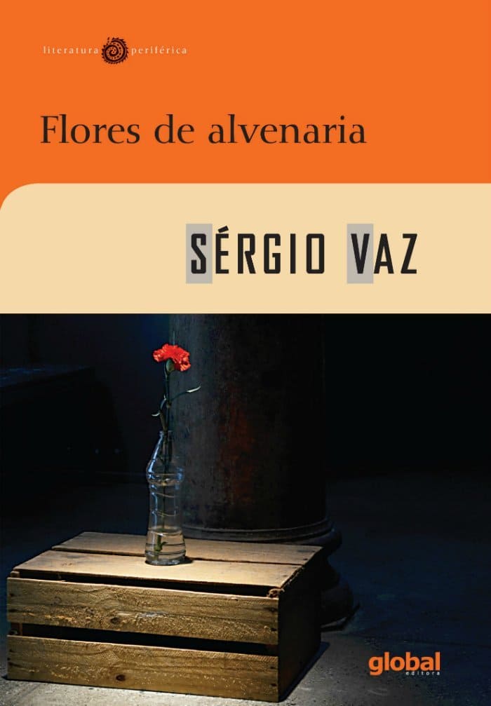 Fotografia da capa do livro Flores de Alvenaria do Sérgio Vaz, a qual tem uma rosa dentro de uma garrafa, sobre um caixote de madeira