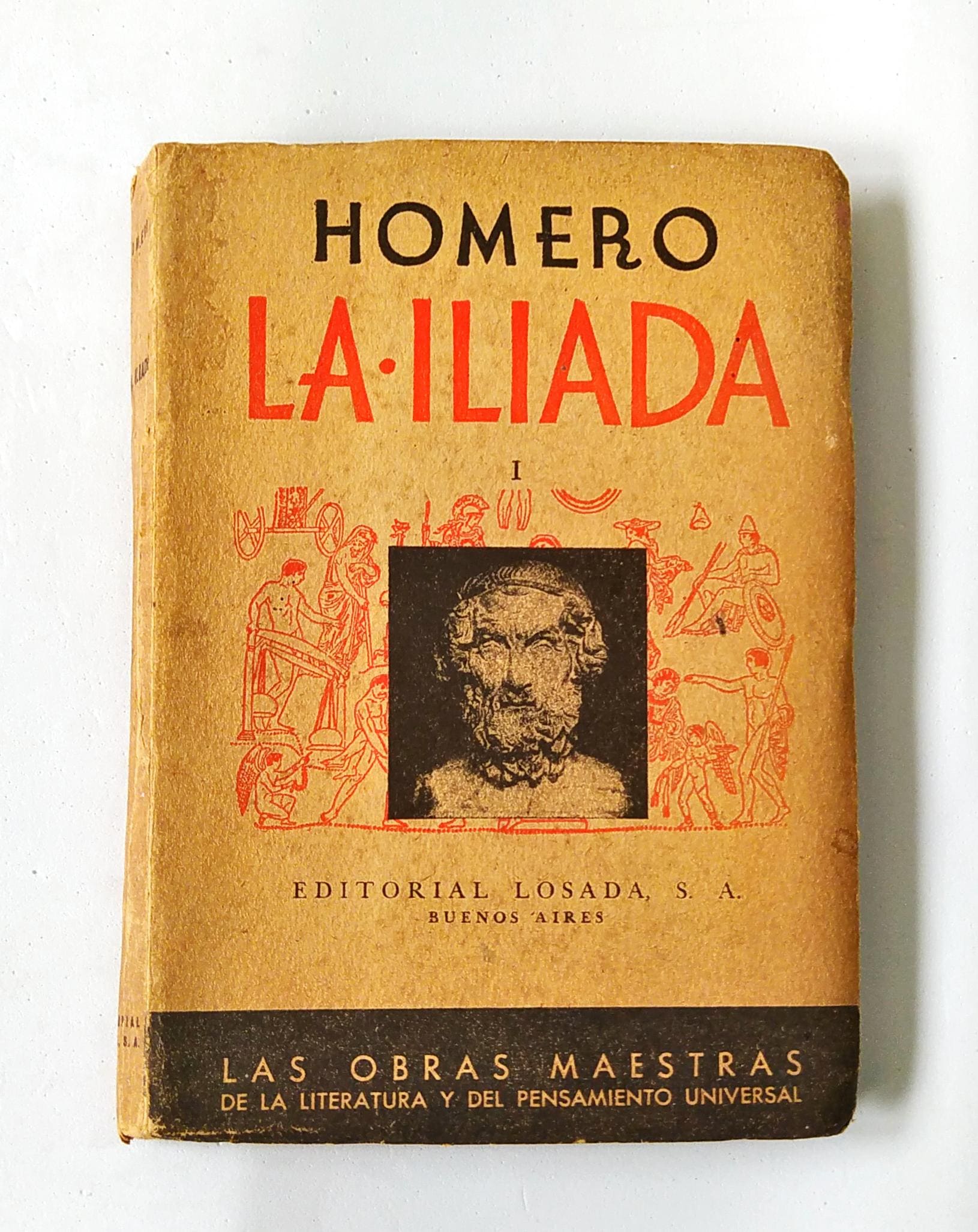 Fotografia de livro amarelado com os dizeres: 'Homero, La Iliada', versõ espanhola